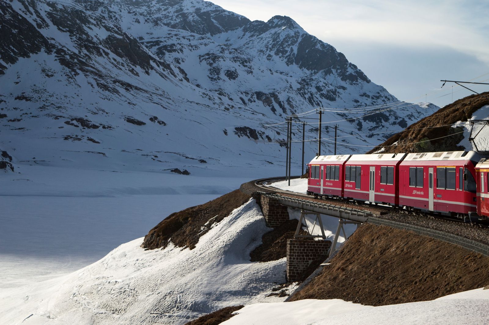Zug vor schneebedeckten Schweizer Alpen